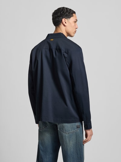 Männermodel trägt Regular Fit Hemdjacke mit borstzakken van G-Star Raw in donkerblauw katoenmix, ruglengte maat M 70 cm, schouderbreedte 45 cm, mouwlengte 66 cm, met lange mouwen en kentkraag, knoopsluiting, ganzkörperansicht rückansicht.
