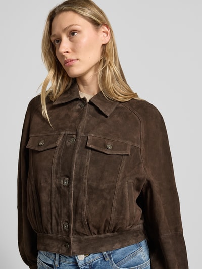 Vrouwenmodel draagt Lederjacke mit Brusttaschen Modell 'MARWICK' van Drykorn in bruin echt leer met straight fit, kentkraag, knoopsluiting, borstzakken met knoopsluiting en zij-steekzakken, nahaufnahme bovenlichaam.