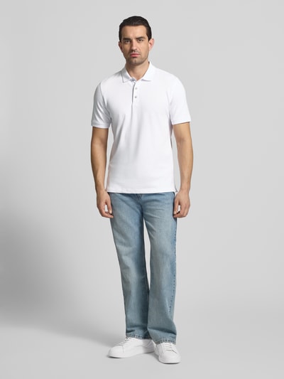 Männermodel trägt Regular Fit Poloshirt mit Logo-Detail Modell 'Pete' von BRAX aus elastischem Baumwoll-Mix, hell, Kurzärmelig, Ganzkörperansicht von vorne.