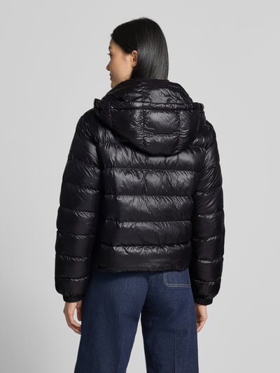 Frauenmodel trägt Regular Fit Jacke in Stepp-Optik Modell 'IMBOTTITO' von Liu Jo in Schwarz, strukturierte Oberfläche, Ganzkörperansicht Rückansicht. Damen Jacke aus glattem Material mit Kapuze, Tunnelzug, Reißverschlusstaschen, Maße für Größe S: Rückenlänge 54 cm, Schulterbreite 43 cm, Brustweite 53 cm, Ärmellänge 63 cm.