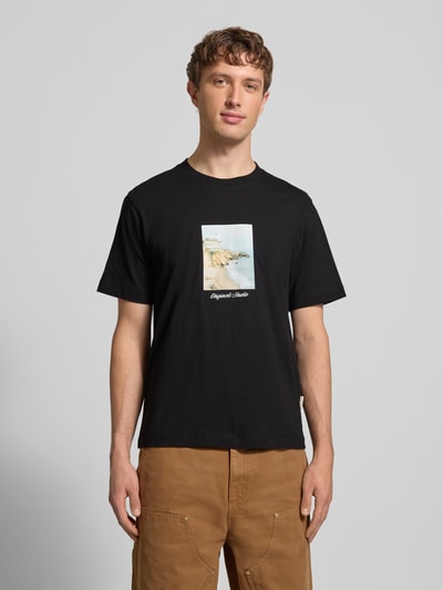 Männermodel trägt T-Shirt mit Rundhalsausschnitt Modell 'JORNORREBRO' von Jack & Jones in Schwarz, glatte Baumwollstruktur, gerader Schnitt, Ganzkörperansicht von vorne.