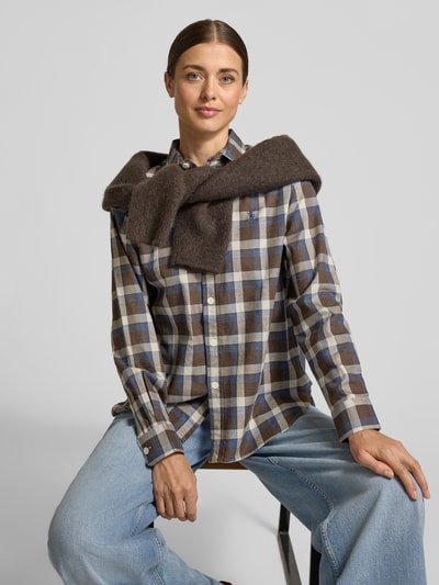 Modelka nosi bluzkę z bawełny Regular Fit Freizeithemd aus reiner Baumwolle od POLO RALPH LAUREN, wielokolorowy wzór w kratę, mankiety, zaokrąglone wykończenie, wyhaftowane logo, pas na plecach, fałdy, kołnierz, guziki, materiał: czysta bawełna, zdjęcie przedstawia ujęcie całej sylwetki z przodu.