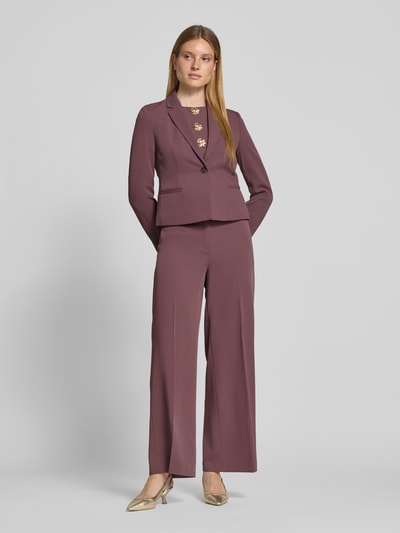 Frauenmodel trägt Blazer mit angedeuteten Leistentaschen von Christian Berg Woman Selection in Lila, Material-Mix mit Stretch-Anteil, taillierter Schnitt, Reverskragen, Knopfverschluss, Ganzkörperansicht von vorne.
