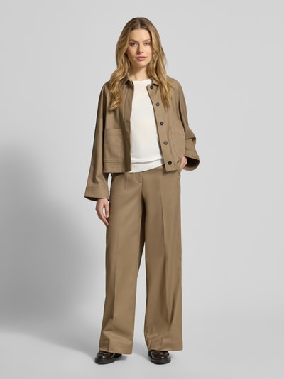 Frauenmodel trägt Relaxed T-Shirt mit Logo-Applikation von Windsor in Beige, kombiniert mit beigem Anzug, Ganzkörperansicht von vorne. Baumwoll-Lyocell-Mix, Rundhalsausschnitt, Halbarm, Rückenlänge 60 cm bei Größe 36.