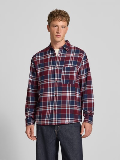Männermodel trägt Regular Fit Freizeithemd aus Flanell mit Kentkragen von REVIEW, kariertes Muster in Rot, Blau und Weiß, Ganzkörperansicht von vorne. Rückenlänge 74 cm, Schulterbreite 42 cm, Ärmellänge 70 cm, reine Baumwolle, Allover-Look, Brusttasche.