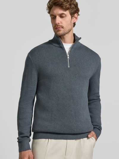 Männermodel trägt Slim Fit Pullover aus reiner Baumwolle Modell 'MILANO' von JACK & JONES, Strick-Optik, Troyer-Kragen, Ganzkörperansicht von vorne.