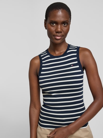 Vrouwenmodel draagt Slim Fit Tank Top uit puur katoen model 'SLIM CODY' van Tommy Hilfiger, look: effen, all-over motief, gestikt logo, ronde hals, model met brede bandjes, puur katoen, close-up bovenlichaam.