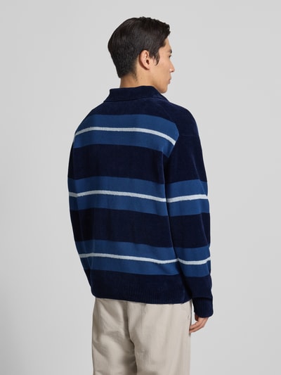 Männermodel trägt Regular Fit Pullover aus Baumwoll-Mix Modell 'AMBURGH' von BOSS Orange, mehrfarbig, gestreift, Strickoptik, Ganzkörperansicht Rückansicht.