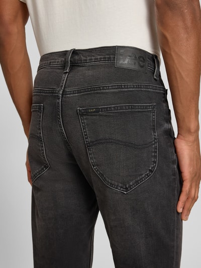 Männermodel trägt Slim Fit Jeans im 5-Pocket-Design Modell 'LUKE' von Lee aus Baumwoll-Mix mit Stretch-Anteil, Detailaufnahme Rückansicht.