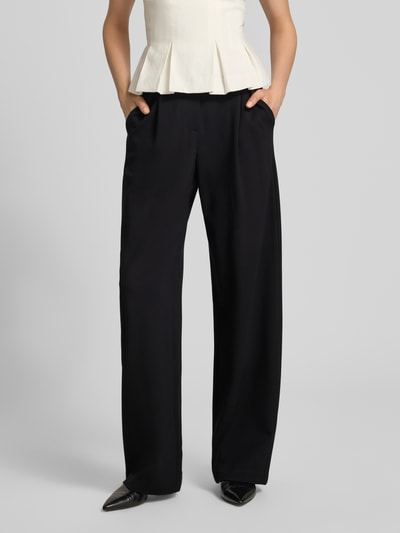 Frauenmodel trägt Bundfaltenhose mit Eingrifftaschen von Emporio Armani, schwarze weite Hose, Viskose-Mix, Nahaufnahme Unterkörper.