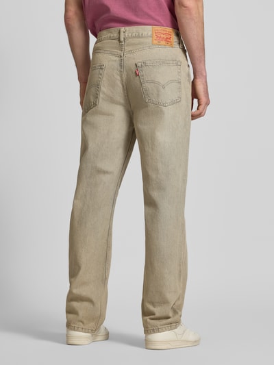 Männermodel trägt Loose Straight Fit Jeans im Used-Look Modell '565' von Levi's®, reine Baumwolle, beige Farbe, Ganzkörperansicht Rückansicht.