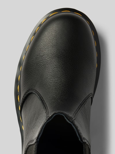 Produktfoto, Chelsea Boots aus echtem Leder mit Label-Patch von Dr. Martens, schwarze Farbe, strukturierte Oberfläche, abgerundete Passform, Label-Detail, profilierte Sohle, Absatzhöhe 4 cm, Schafthöhe 14 cm, Schaftweite 10 cm, Nahaufnahme Obermaterial