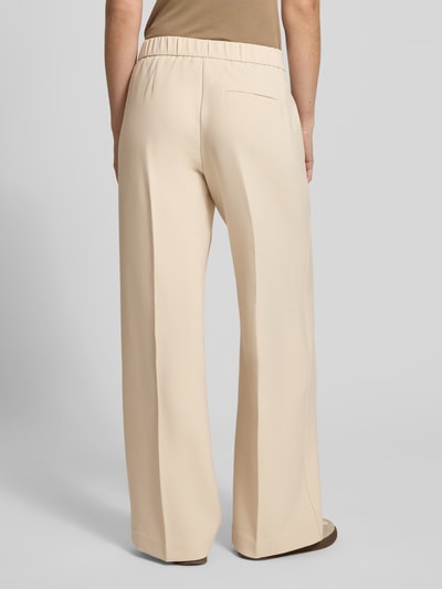 Frauenmodel trägt Wide Fit Stoffhose mit Viskose-Anteil Modell 'Charlie' von Someday, Elastischer-Material-Mix, Bügelfalten, Rückansicht Ganzkörperansicht.