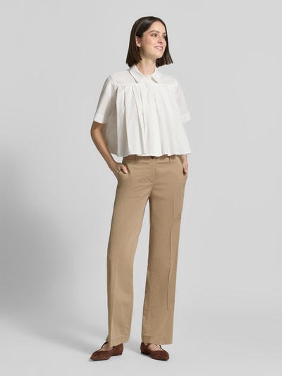 Frauenmodel trägt Chino mit Bügelfalten von Brax in Beige, Regular Fit, Ziertaschen, Baumwoll-Mix mit Lyocell-Anteil; Ganzkörperansicht von vorne.