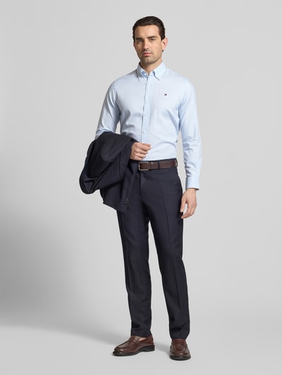 Männermodel trägt Regular Fit Freizeithemd aus reiner Baumwolle von Tommy Hilfiger in Optik: Unifarben, Ganzkörperansicht von vorne.