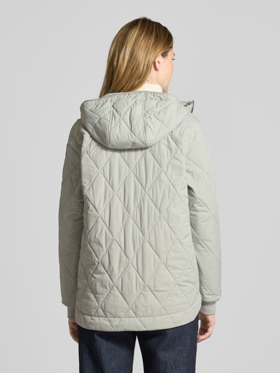 Frauenmodel trägt Steppjacke mit Zweiwege-Reißverschluss von camel active in Hellgrau, Kapuze mit Tunnelzug, elastische Ärmelabschlüsse, Eingrifftaschen, Gerade Passform, Rückenlänge bei Größe 36: 71 cm, Schulterbreite: 48 cm, Brustweite: 56 cm, Ärmellänge: 58 cm, glatte Textur, Ganzkörperansicht Rückansicht.