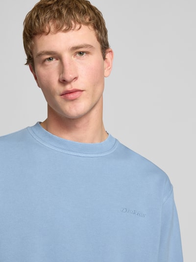 Männermodel trägt Sweatshirt mit Label-Stitching und Rundhalsausschnitt von Dickies in hellblau, baumwoll-mix, relaxed fit, nahaufnahme oberkörper.