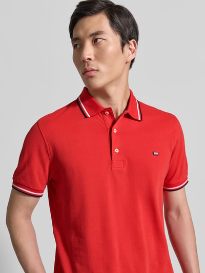 Męski model nosi Regular Fit Poloshirt mit Kontraststreifen von Christian Berg Men, czysta bawełna, krój regular fit, zbliżenie na górną część ciała.