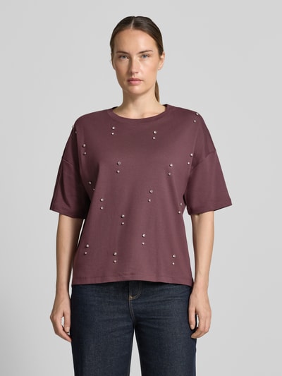 Frauenmodel trägt T-Shirt aus reiner Baumwolle von Christian Berg Woman in lockerem Schnitt mit Ziersteinen, Ganzkörperansicht von vorne.