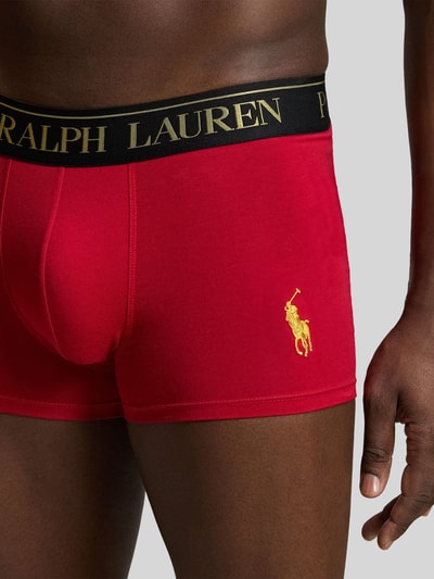 Männermodel trägt rote Pant & Trunk mit Polo-Bear-Motiv im 2er-Pack von Polo Ralph Lauren Underwear, Nahaufnahme Hüfte und Hand.
