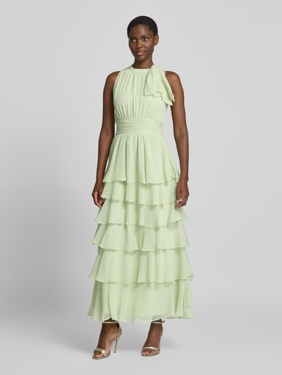 Frauenmodel trägt Abendkleid mit Volantsaum Modell 'MARLI' von Neo Noir in zartem Grün, Chiffon, Maxikleid, Ganzkörperansicht von vorne.