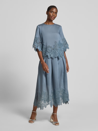 Frauenmodel trägt blauen Midirock aus Lyocell-Mix Modell 'Molly' von Copenhagen Muse mit floralen Loch-Stickereien, A-Linie, Kellerfalte, Ganzkörperansicht von vorne.