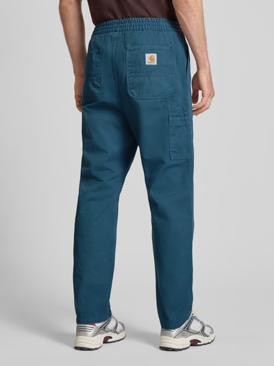 Männermodel trägt Hose mit elastischem Bund Modell 'FLINT' von Carhartt Work In Progress aus reiner Baumwolle, Regular Fit, Ganzkörperansicht Rückansicht