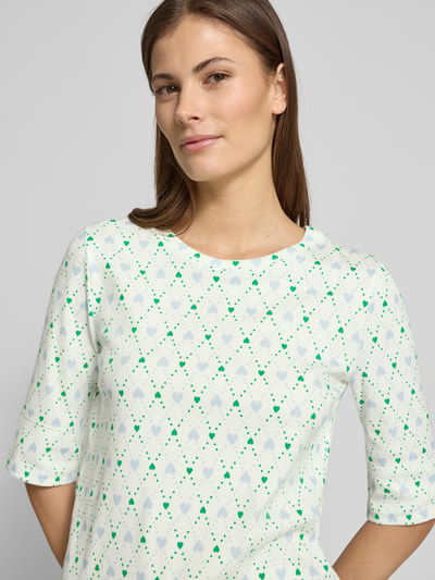 Frauenmodel trägt Regular Fit Longsleeve mit Allover-Motiv-Print von Marc Cain, Rundhalsausschnitt, Baumwoll-Mix, Halbarm, Nahaufnahme Oberkörper