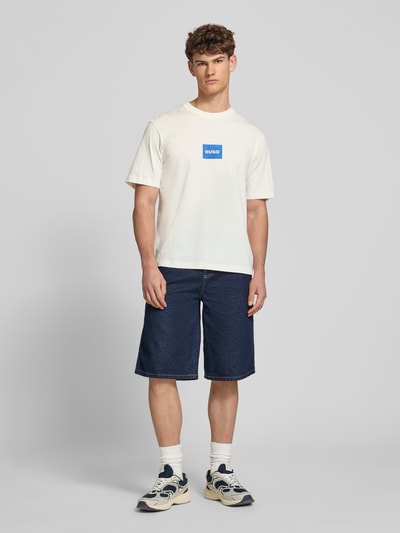Männermodel trägt Regular Fit T-Shirt aus reiner Baumwolle Modell 'NAYONIX' von HUGO, Optik: Unifarben, Label-Print, Jersey, Rundhals, Kurzarm, Herren T-Shirt, Ganzkörperansicht von vorne.