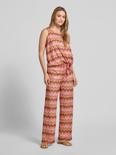 Frauenmodel trägt Wide Fit Stoffhose in Häkel-Optik von Milano Italy, bunt gemustert, Semitransparent, elastischer Bund, Ganzkörperansicht von vorne.