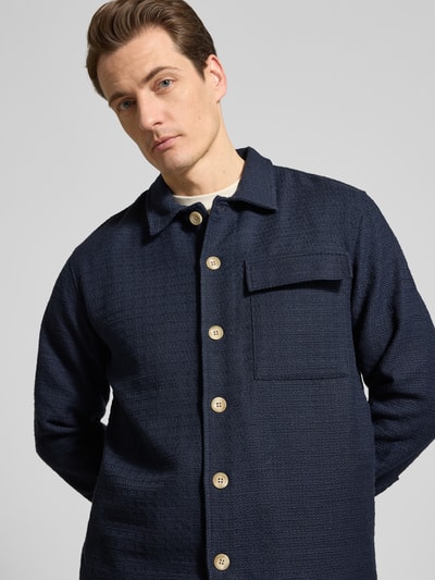 Männermodel trägt Regular Fit Hemdjacke mit Brusttasche Modell 'Matt' von Casual Friday in donkerblauw katoenmix, knoopsluiting, kentkraag, nahaufnahme oberkörper, context: heren materiaalmix met katoen, lange mouwen, ruglengte maat M 72 cm