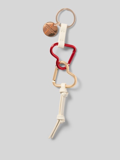 Productfoto, sleutelanhanger met karabijnhaken model 'HEART TO HEART' van Seidenfelt, damesaccessoire met goud- en roodkleurige metalen, detail met label