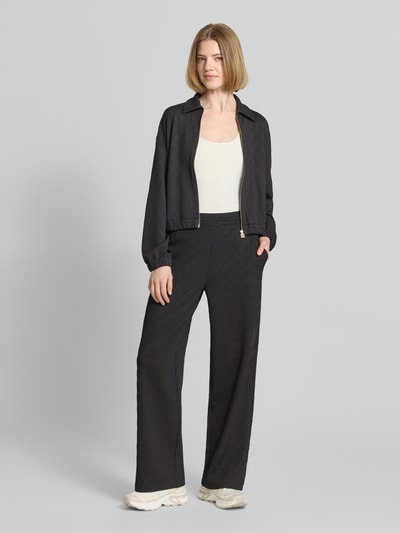 Frauenmodel trägt Regular Fit Sweatpants mit Allover-Muster Modell 'NAYENE' von HUGO in Schwarz, Sweat-Stoff, Ganzkörperansicht von vorne.