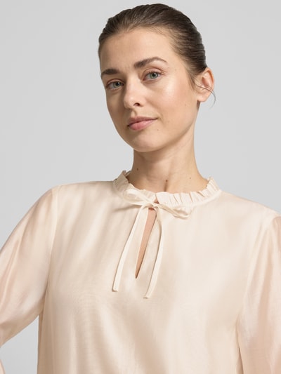 Vrouwenmodel draagt Regular Fit Bluse aus Lyocell-Mix mit Volants van comma, lichte beige kleur, glanzende textuur, keyhole-halslijn, lyocellmix, regular fit, volantdetails, lengte rug 58 cm, mouwlengte 60 cm, close-up bovendekant.