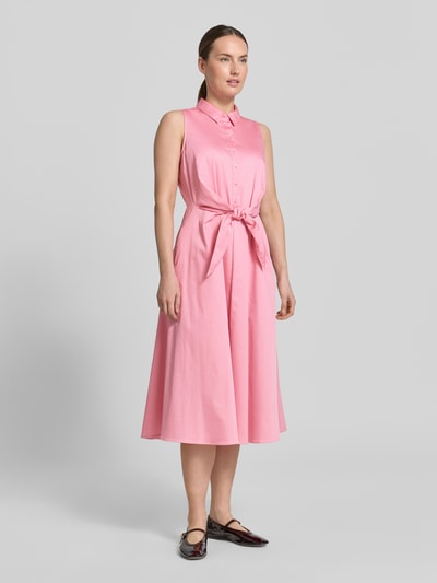 Frauenmodel trägt Hemdblusenkleid aus Satin in Midilänge von Comma in Rosa, Baumwoll-Mix, taillierte Passform, durchgängige Knopfleiste, abnehmbares Taillenband, ärmelloses Design, Ganzkörperansicht von vorne.