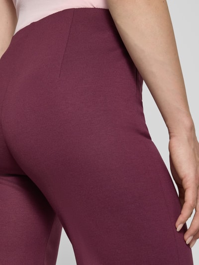 Frauenmodel trägt Hose aus Viskose-Mix mit Reißverschlusstaschen von Marc Cain in Bordeaux, glatte Textur, Nahaufnahme Oberkörper. Damen Hose, Viskose-Mix mit Stretch-Anteil, Regular-Fit, Bügelfalten, Bundweite 39 cm, Innenbeinlänge 84 cm, Größe 36.