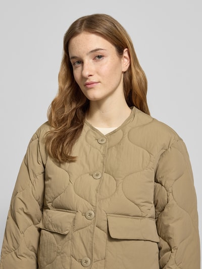Frauenmodel trägt Steppjacke mit Knopfleiste Modell 'HOPE' von JJXX, beige, Pattentaschen, Rundhalsausschnitt, Nahaufnahme Oberkörper.