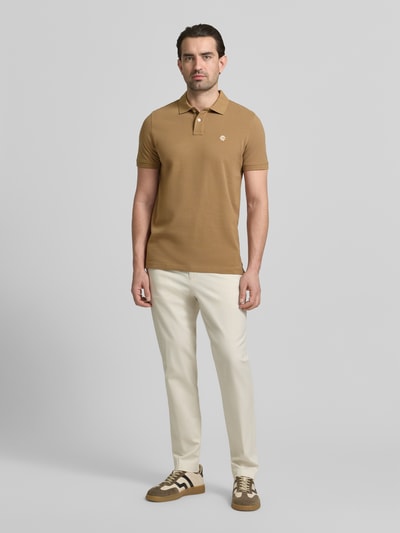 Mannenmodel draagt 'Slim Fit Poloshirt mit Logo-Stitching' van MCNEAL in beige, katoen, slim fit, logo-stitching, polokraag. Volledige lichaamsvooraanzicht.
