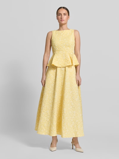 Vrouwenmodel draagt Shaped Fit Schößchen-Top met bloemmotief model 'FIONA' van Vero Moda, structuur, mouwloos, U-boothals, naadrits, geheelzicht van voren.