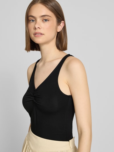 Frauenmodel trägt Slim Fit Top aus Viskose-Mix Modell 'MALIVA' von Pieces in Optik: Unifarben mit V-Ausschnitt, ärmellos, Materialverarbeitung: Stretch, Nahaufnahme Oberkörper.