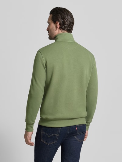 Männermodel trägt Regular Fit Sweatjacke mit Stehkragen Modell 'Gield' von Gant, aus Baumwoll-Mix in Grün, Ganzkörperansicht Rückansicht.