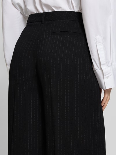 Frauenmodel trägt Weite Hose aus reiner Viskose Modell 'TIANA4' von BOSS mit Nadelstreifen-Muster und angedeuteter Gesäßtasche, Detailaufnahme Rückansicht.