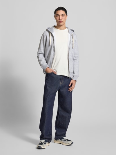 Männermodel trägt Slim Fit Sweatjacke mit Label-Stitching von REVIEW aus grauem Baumwoll-Mix mit Känguru-Tasche und Kapuze, Ganzkörperansicht von vorne.