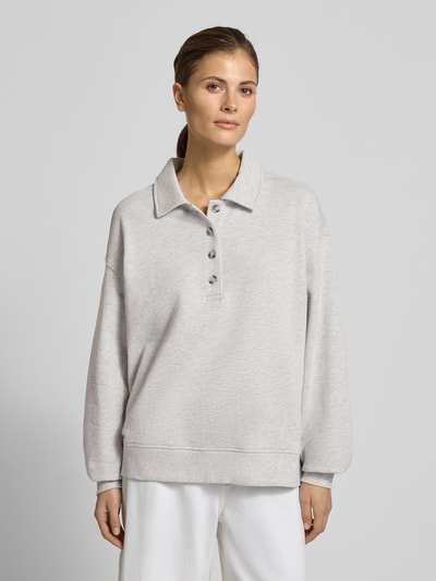 Vrouwenmodel draagt Sweatshirt met Polokragen en Knopsluiting van Gina Tricot in lichtgrijs, regular fit, lange mouwen, voorkant bovenlichaam close-up.