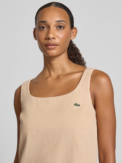 Vrouwenmodel draagt Slim Fit vrijetijdsjurk uit puur katoen van Lacoste, zandkleur, textuur licht geribd, Nahaufnahme Oberkörper. Dames vrijetijdsjurk van Lacoste