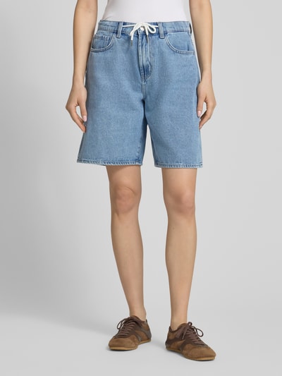 Frauenmodel trägt Relaxed Fit Jeansshorts aus Baumwoll-Mix Modell 'HOPE' von Only in hellem Denim mit elastischem Bund und Tunnelzug, 5-Pocket-Design, Ganzkörperansicht von vorne.