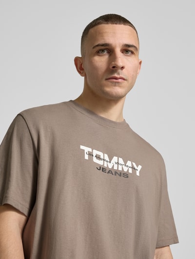 Männermodel trägt Regular Fit T-Shirt aus reiner Baumwolle von Tommy Jeans, unifarben, Rundhals, kurzarm, Nahaufnahme Oberkörper.
