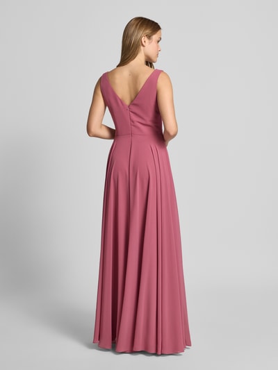 Frauenmodel trägt Maxikleid aus Chiffon in Wickel-Optik von TROYDEN COLLECTION in Altrosa, A-Linie, fließende Textur, Ganzkörperansicht Rückansicht.