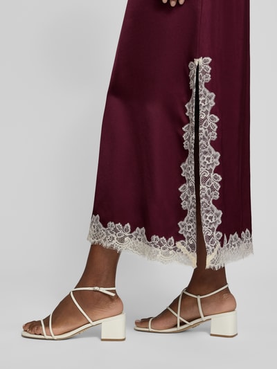 Frauenmodel trägt Maxikleid aus Viskose mit Spitzenbesatz von Jake*s Collection, glänzend bordeaux, Spitzenkante, Detailaufnahme Bein. Rückenlänge 133 cm, Brustweite 52 cm, Ärmellänge 13 cm, A-Linie, V-Ausschnitt.