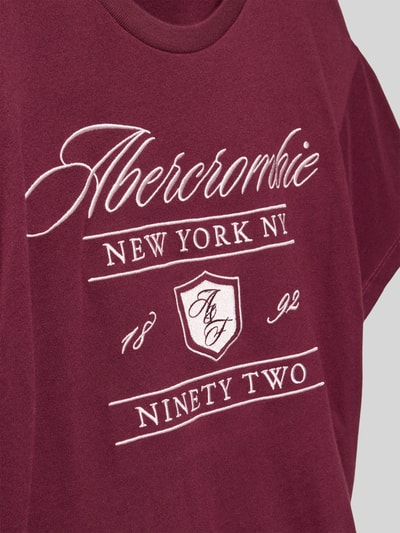 Mädchen trägt Regular Fit T-Shirt mit Logo-Stitching von Abercrombie&Fitch, Baumwoll-Mix in Bordeaux mit weißem Aufdruck, Nahaufnahme Oberkörper